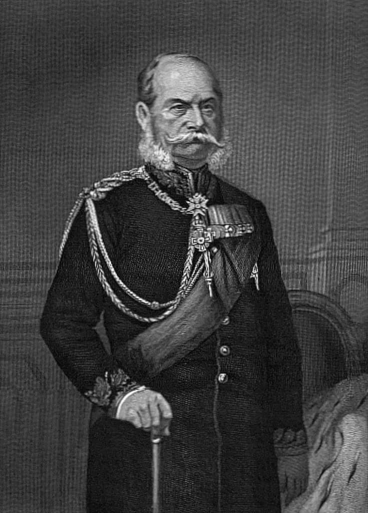 König Wilhelm I. v. Preußen in großer Generalsuniform; nach 1870 Wilhelm I. ist in Generalsuniform (sog. "gestickter Rock" [-> die Bezeichnung rührt von der Eichenlaubstickerei am Kragen und den Aufschlägen her]) mit großer Ordensdekoration dargestellt. Da das Bild schwarz-weiß: Zur Farbgebung: Der Rock dunkelblau, der Kragen und die -sog. "schwedischen"- Ärmelaufschläge rot, mit goldener Eichenlaubstickerei. Schultergeflecht, Achselband und Knöpfe ebenfalls golden. Der im Hintergrund rechts auf dem Sessel oder Stuhl liegende Hermelinmantel verweist dezent auf die Stellung/Königswürde Wilhelms (sonst könnte es sich bei dem Dargestellten ja auch um einen anderen Kgl. preuß. Offizier im Generalsrang handeln...).